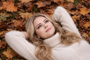 Beautiful Blonde Woman Lying on Autumn Leaves in Nature 4K Desktop Background