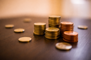 Gold Coins and Copper Pennies Stacked on Wooden Table - 4K Financial Wealth Desktop Wallpaper