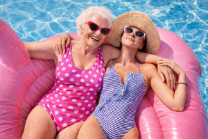 Happy Elderly Mother and Daughter on Inflatable Flamingo Pool Float, Fun Summer Wallpaper, Desktop Background
