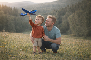 Father and Son Playing with Toy Plane in Nature - Free Desktop Wallpaper